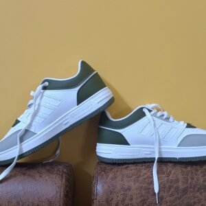 White and green casual shoes elegantly displayed against a yellow backdrop, perfect for fashion concepts.
